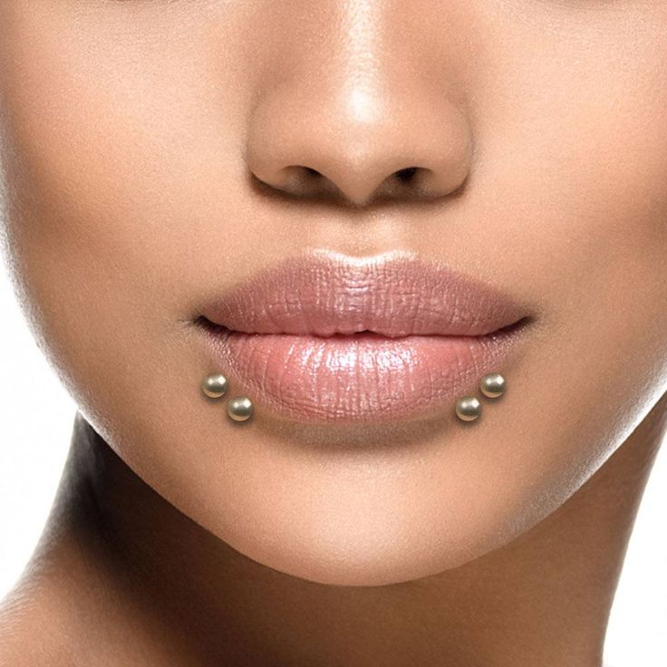 a close up shot of a woman's face with pearls on her lip and nose