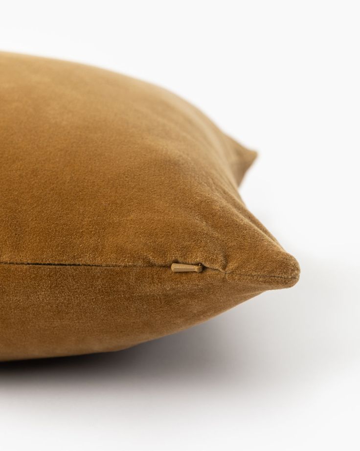 a brown pillow sitting on top of a white table