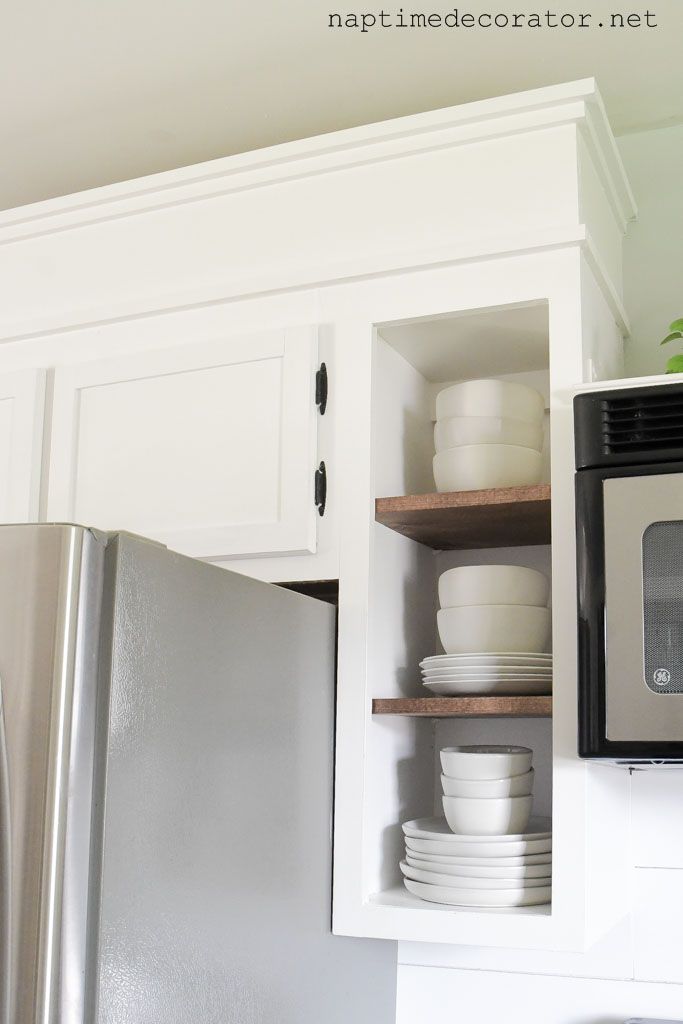 a kitchen with white cabinets and stainless steel appliances in the cupboards that hold dishes