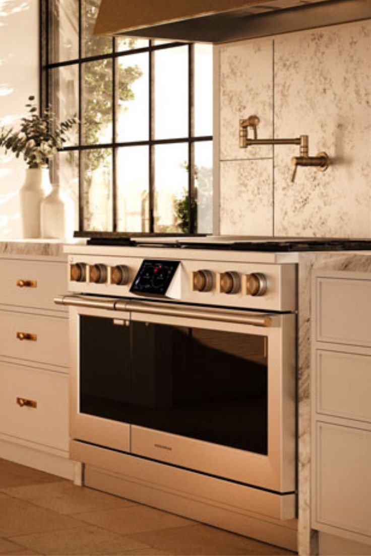 a kitchen with white cabinets and an oven in the middle of the counter top area