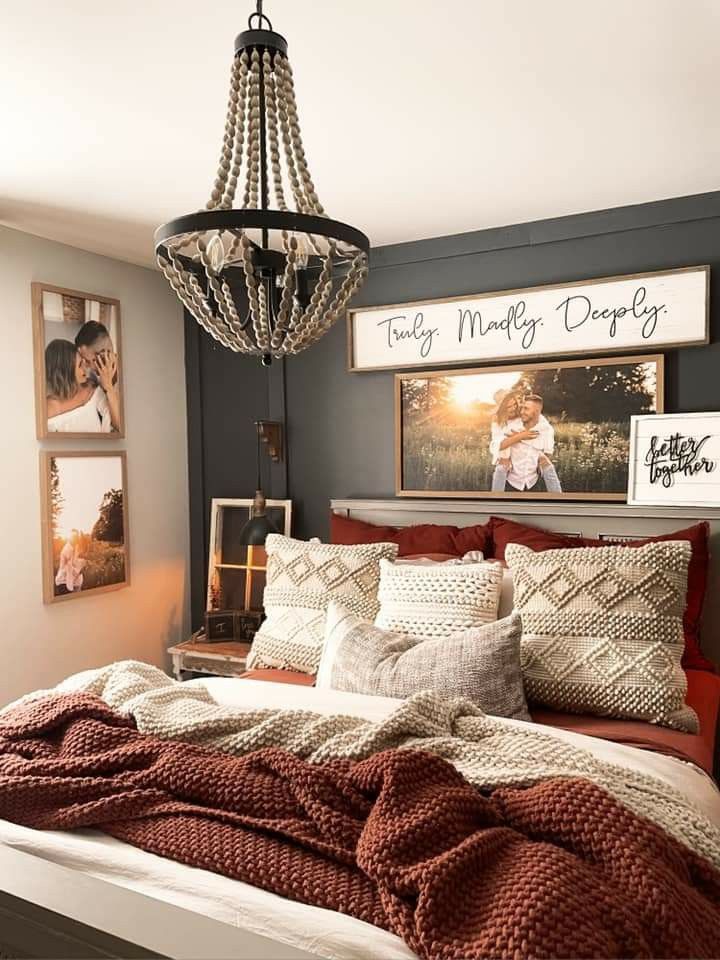 a large bed sitting under a chandelier in a bedroom next to pictures on the wall