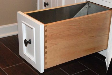 a kitchen cabinet with an open drawer on the bottom and two drawers in the middle