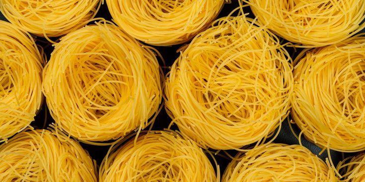 many yellow noodles are stacked on top of each other