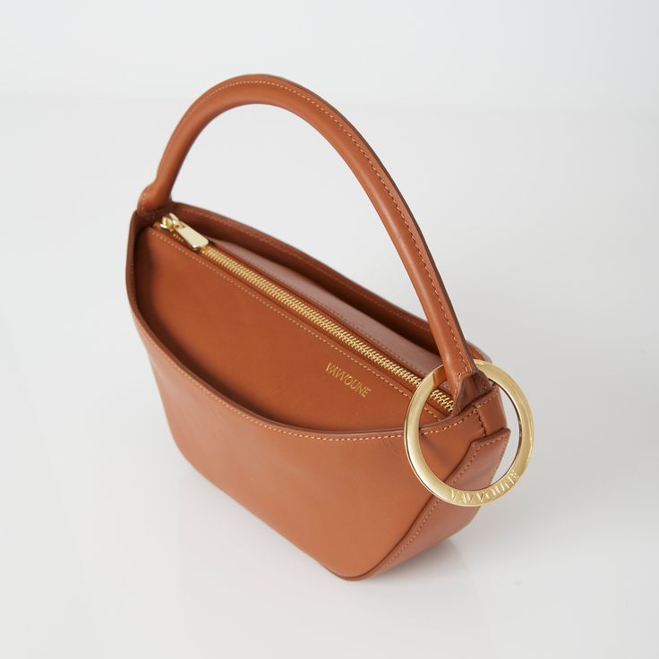 a brown purse with a gold ring on the handle