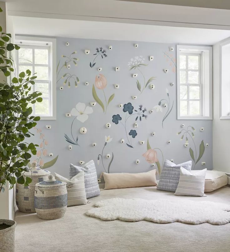 a living room with flowers painted on the wall and rugs in front of it