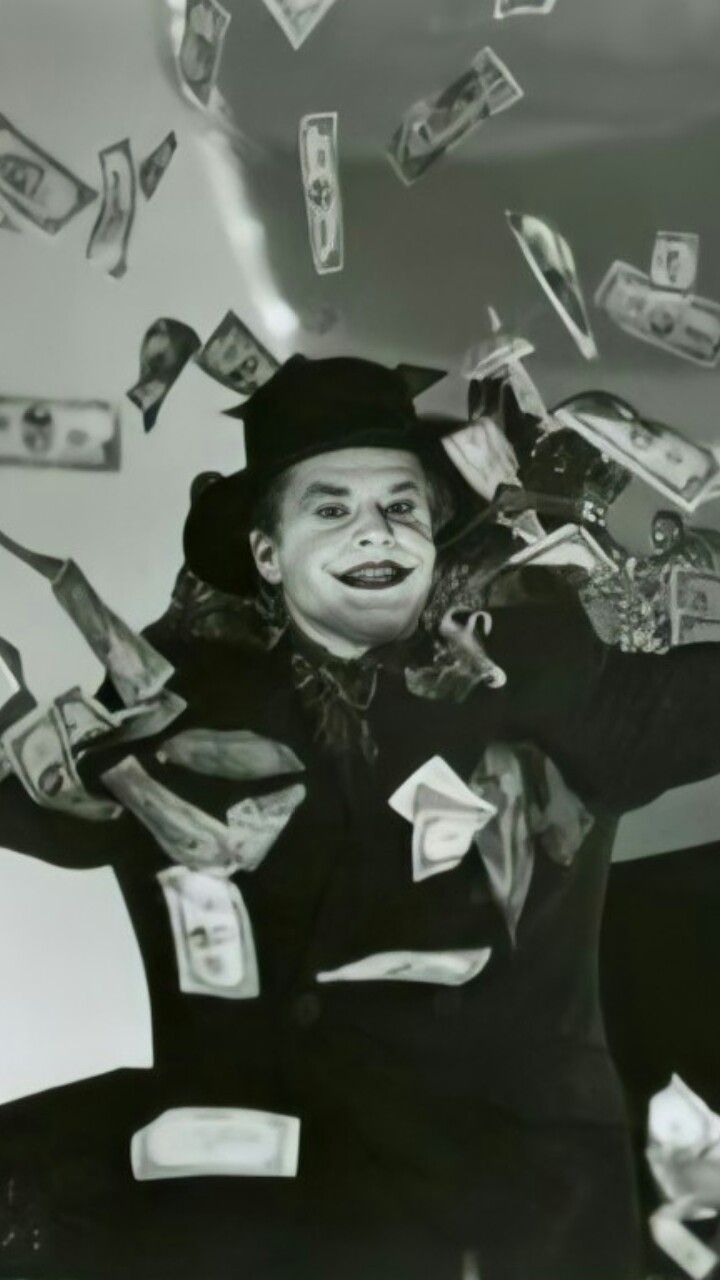 a man sitting on the ground with money falling from his hat and hands in the air