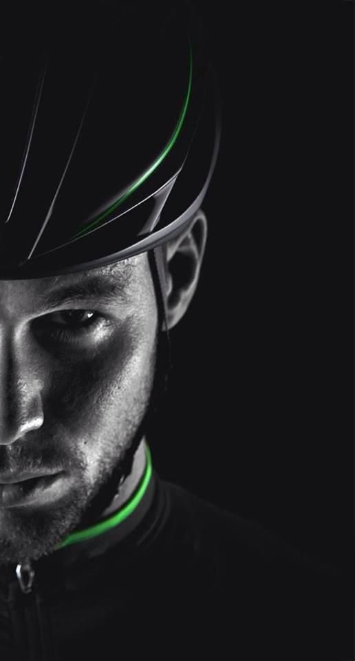 a man wearing a helmet with green lines on it's face and black background