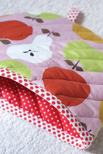 a close up of an oven mitt on the floor with apples printed on it