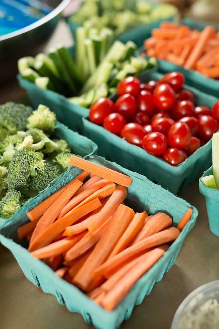 several trays filled with different types of fruits and veggies on a table