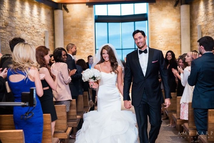 a bride and groom walking down the aisle