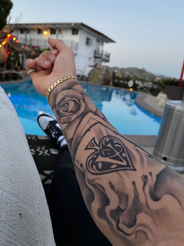 a person with a tattoo on their arm near a swimming pool