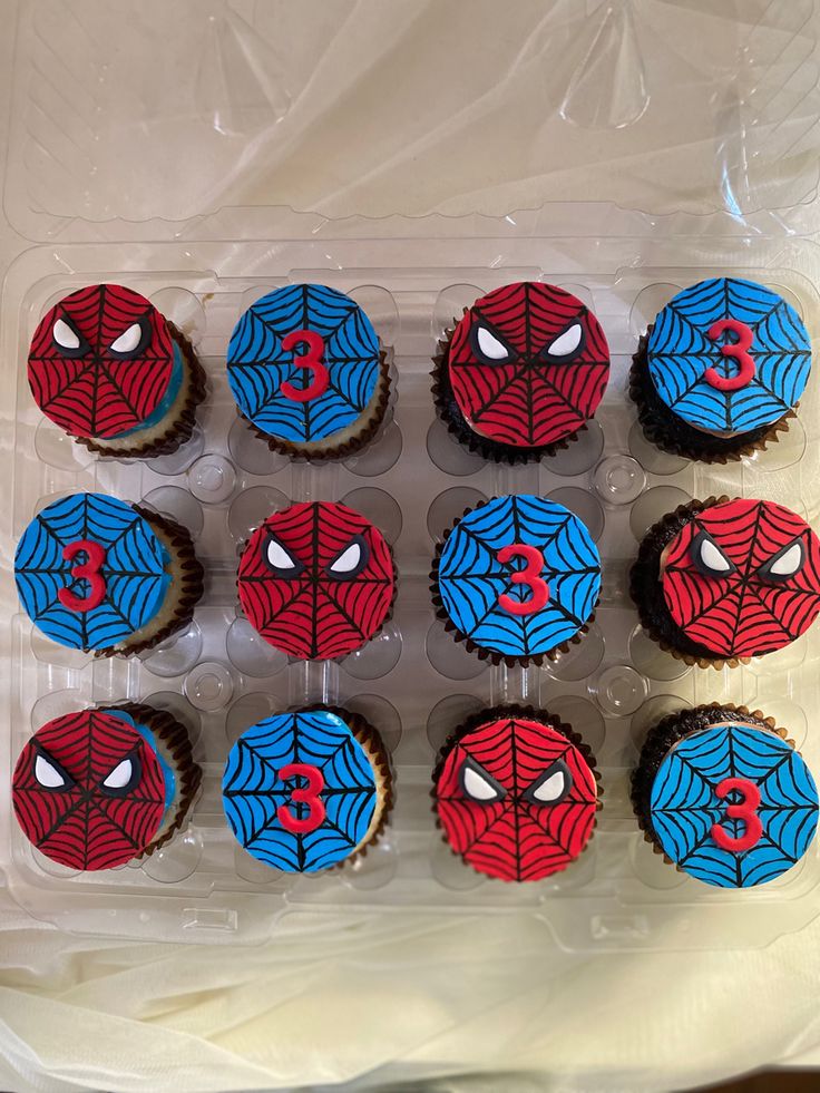 cupcakes decorated with spiderman icing in a plastic container