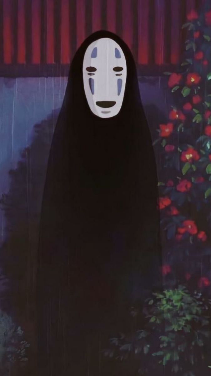 a person with a mask on standing in front of a tree and flowers at night