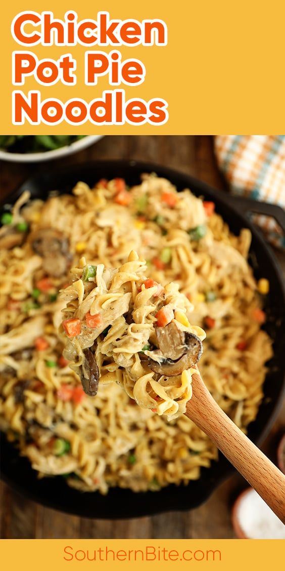 chicken pot pie noodles in a black skillet with a wooden spoon on the side