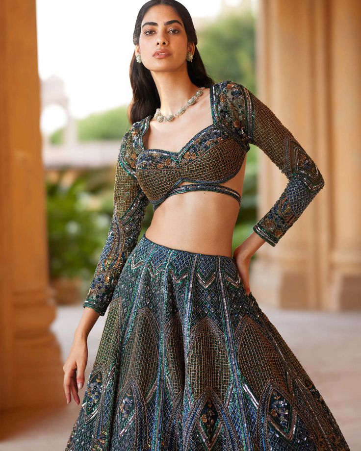 Wrapped in the embrace of emerald green and gold, this lehenga weaves a tale of luxury and celebration. A masterpiece of craftsmanship, adds texture and drama, creating a visual symphony. Sequins and intricate work embellish it with a riot of color. Based on net creating a mesh like effect through out. Paired with a monotone blouse, having full sleeves, it's an ensemble that invites you to step into a world of unparalleled splendor and grace. Emerald Green And Gold, The Embrace, Full Sleeves, Full Sleeve, Green And Gold, Emerald Green, Lehenga, Emerald, Drama