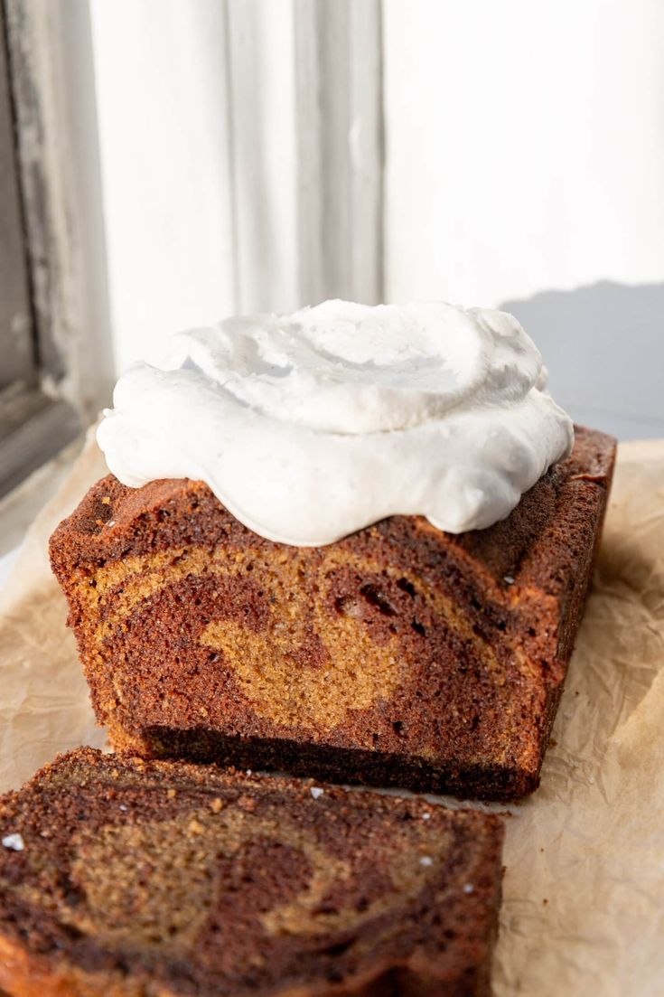 two slices of cinnamon swirl bread with whipped cream on top, sitting next to each other