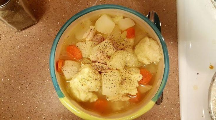 a bowl of soup with carrots and cauliflower in it next to a sink