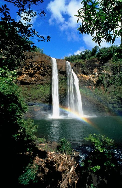 an instagram with a waterfall and rainbow in the background