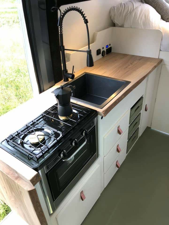 a stove top oven sitting inside of a kitchen next to a sink and countertop