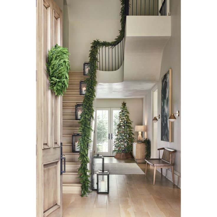 an entry way with stairs and potted plants