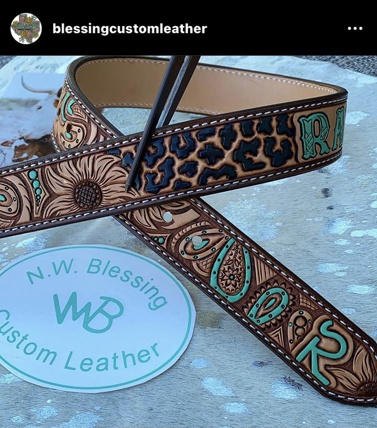 a pair of brown and turquoise western style leather guitar straps with the words n v blessing w b custom leather