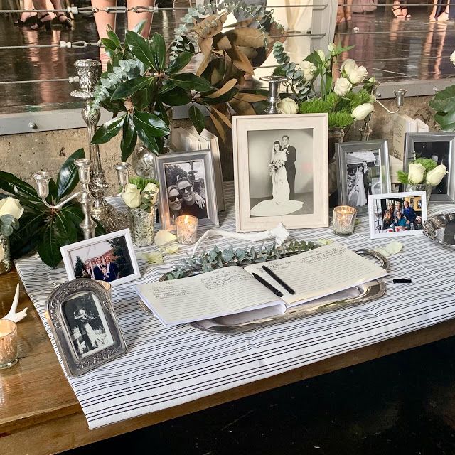 a table topped with pictures and flowers on top of a striped cloth covered tablecloth