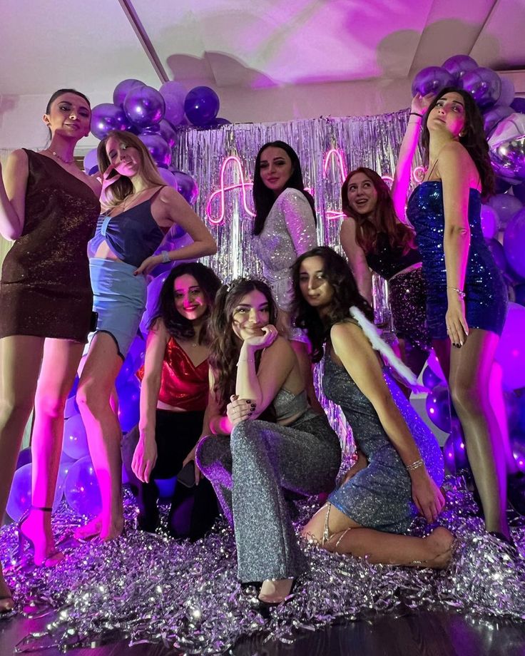 a group of young women posing for a photo in front of balloons and streamers