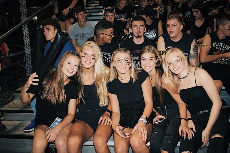 a group of young women sitting next to each other on top of a bleachers