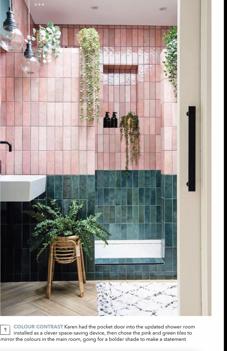 a bathroom with pink and green tiles on the walls, potted plants in the bathtub