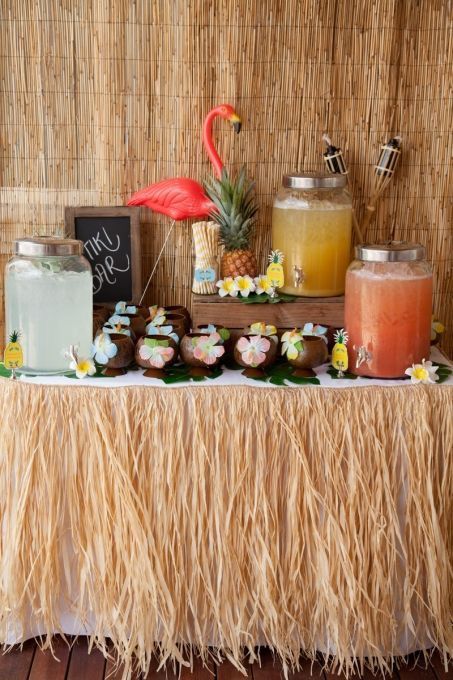 a table topped with lots of desserts next to a tall wall covered in straw