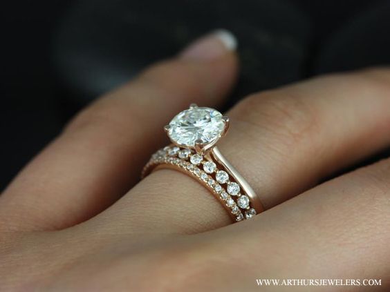 a woman's hand with a diamond ring on top of her finger and the engagement band