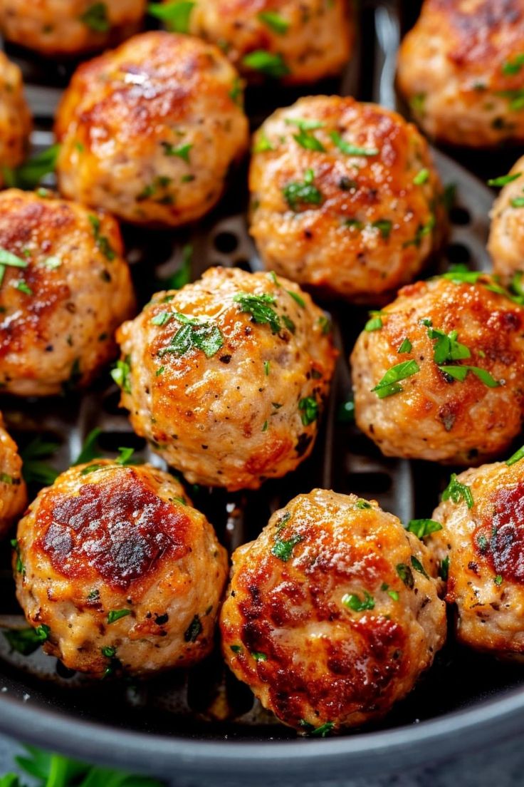 cooked meatballs in a skillet with parsley on top and garnished with herbs