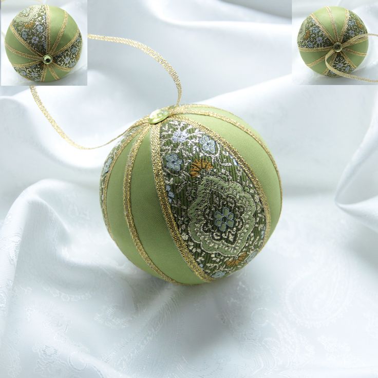 an ornament on a white cloth with gold trimmings and ribbon around it