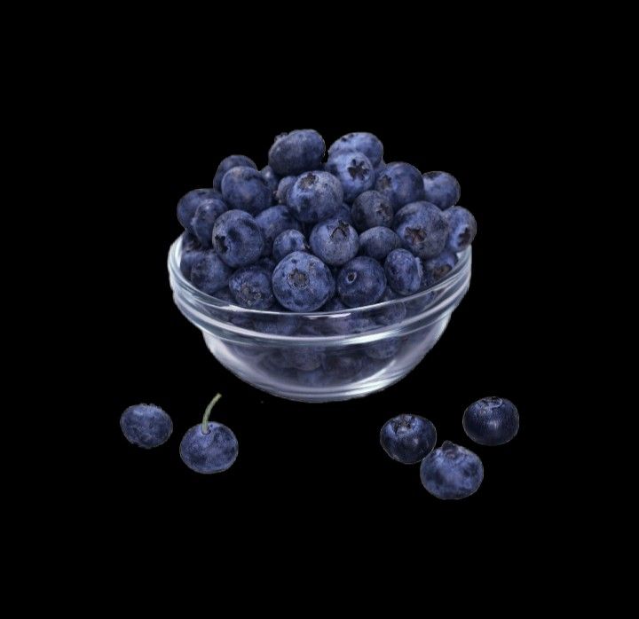 blueberries in a glass bowl on a black background