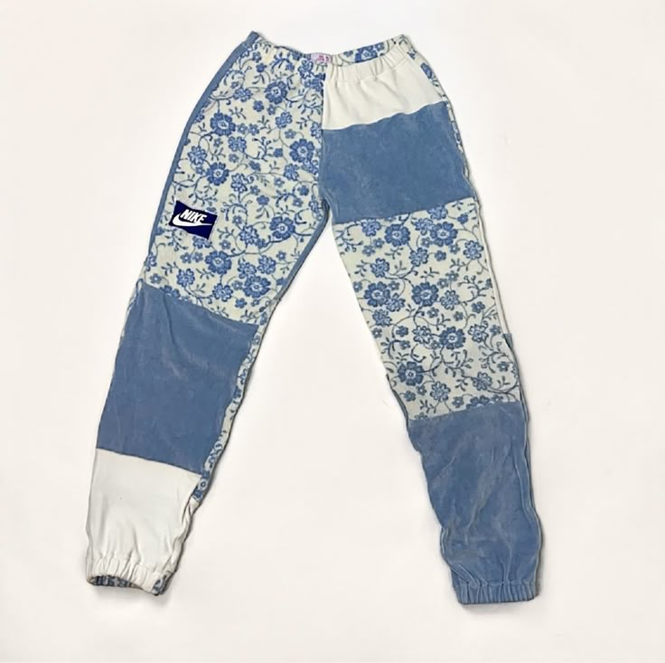 a pair of blue and white pants with flowers on them, sitting on a white surface