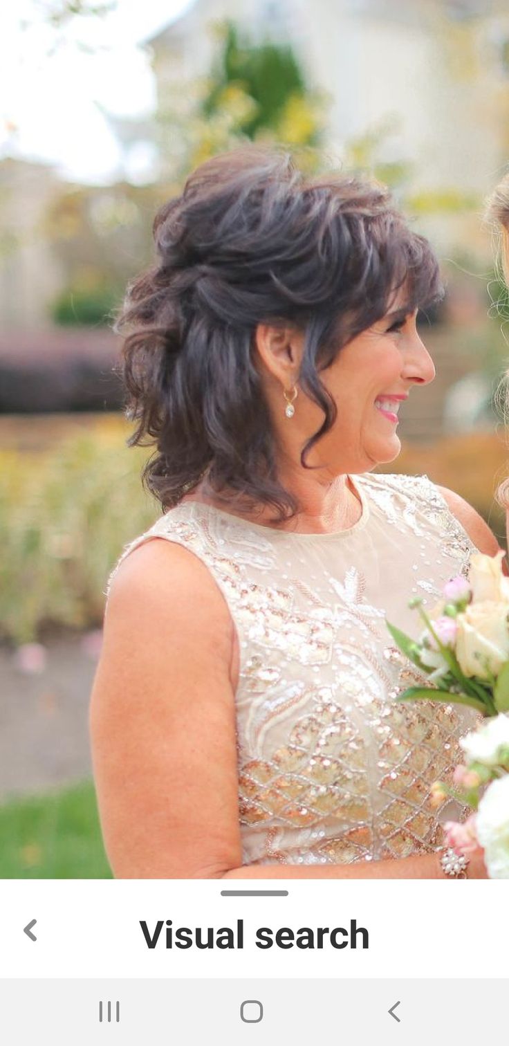 two women standing next to each other holding flowers