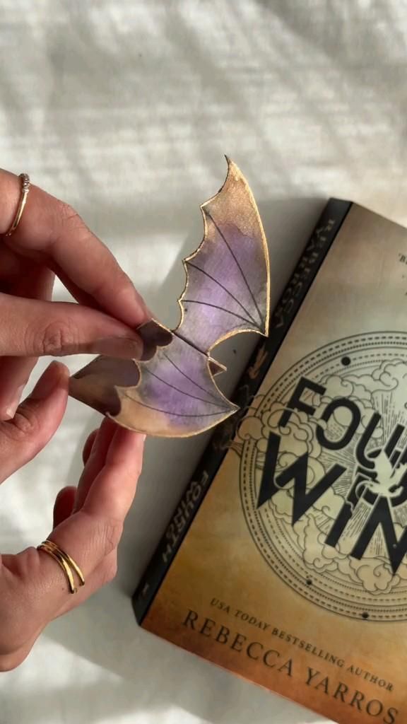 a person is holding a book with a butterfly on it and the title focus win written in spanish