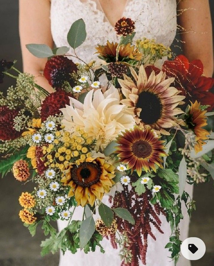 a bride holding a bouquet of sunflowers and greenery