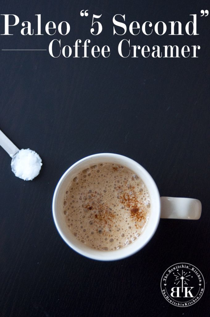 a cup of coffee sitting on top of a table next to a scoop of sugar