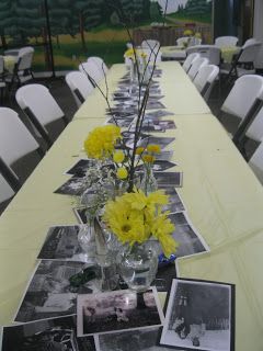 a long table with yellow flowers and pictures on it