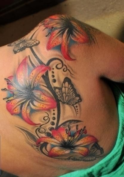 a woman's back with flowers and butterflies on it