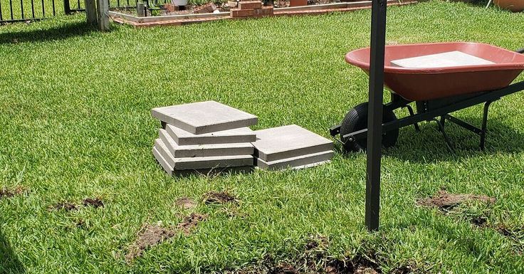 a wheelbarrow with bricks sitting in the grass