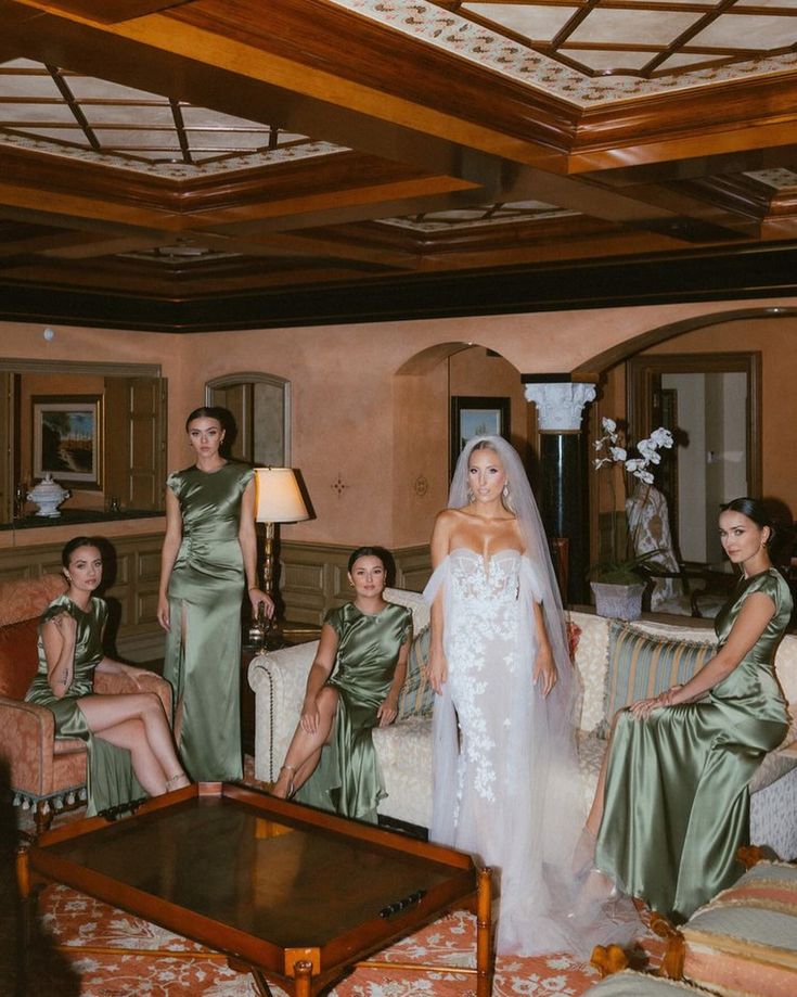 the bride and her bridesmaids pose for a photo in their green wedding gowns