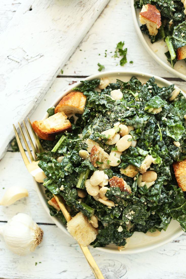 two plates filled with greens and toasted bread