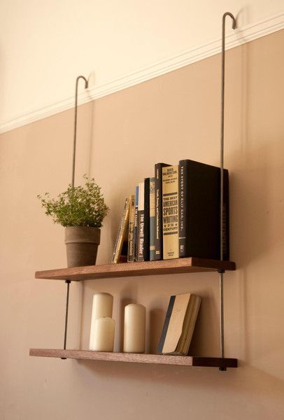 two shelves with books and plants on them