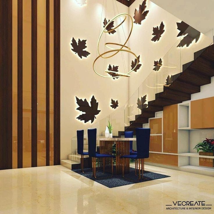 an elegant dining room with modern lighting and wood paneled staircase leading up to the second floor