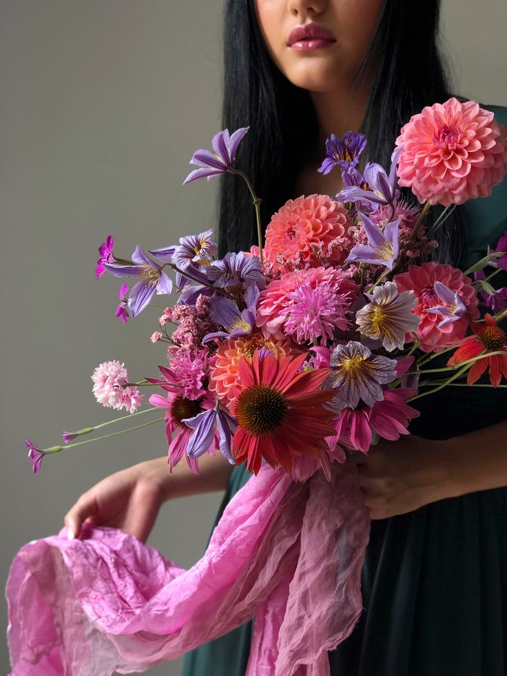 a woman holding a bouquet of flowers in her hands