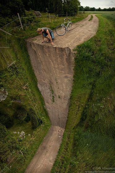 a man riding a bike on top of a dirt hill