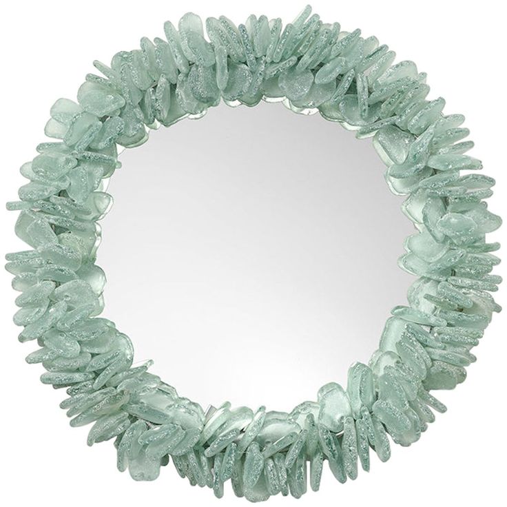 a circular mirror made out of glass with green rocks on the bottom and one side