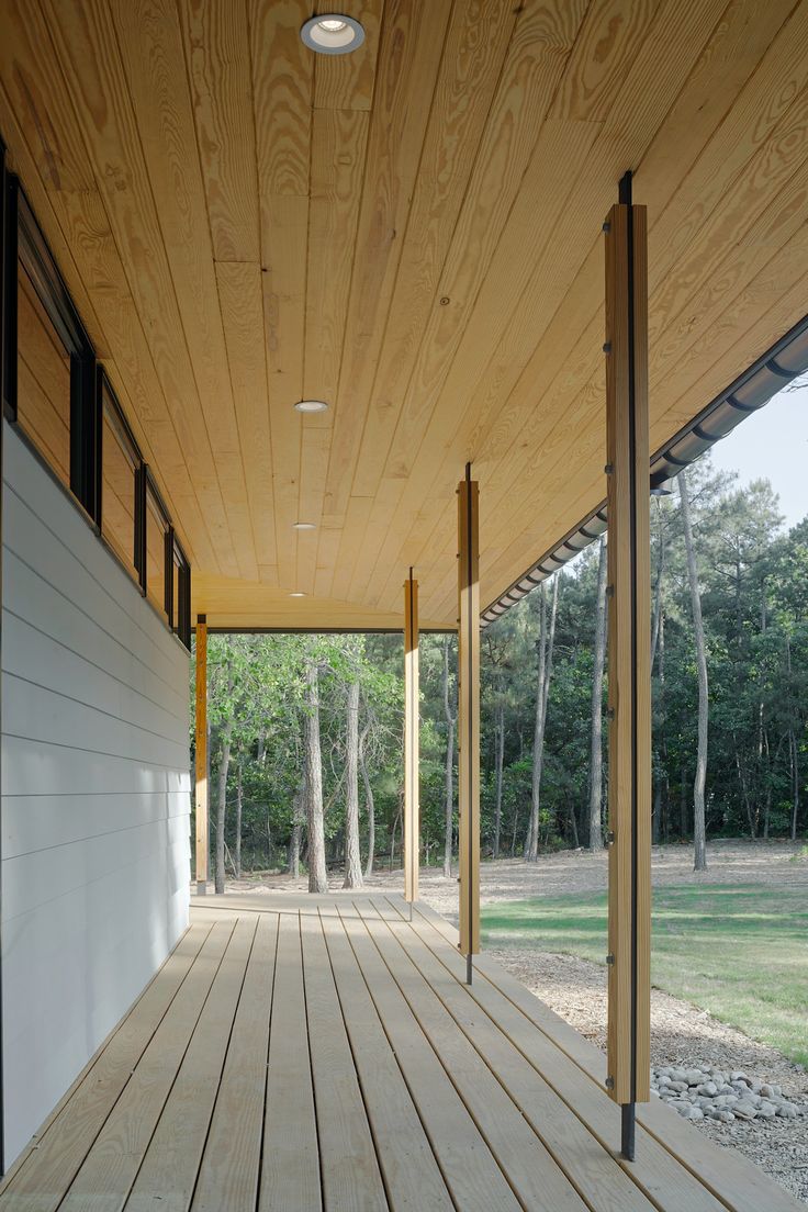 an empty wooden porch with trees in the background